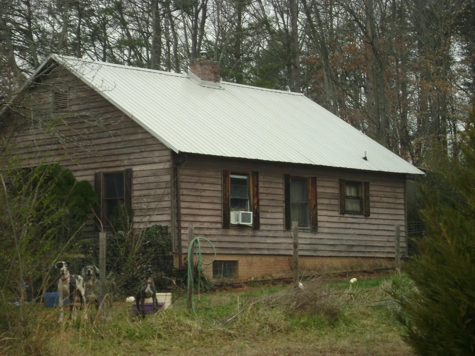 White metal roof on an old wood sided farmhouse, from a Metal Roof Installation job in Industry